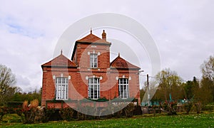 Old red brick hydro-electric power station in the commune of Long on the Somme river