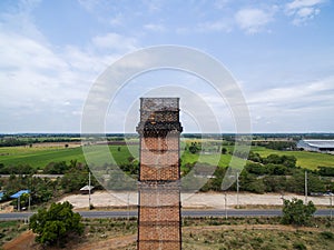 Old red brick smokestack and rice farms background