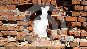 an old red brick stone wall with a hole in the middleisolated against a white background