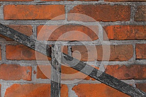 Old red brick wall with Diagonal wooden board - background texture