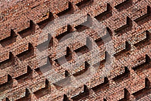 Old red brick wall with protruding blocks as background