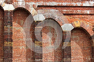 Old red brick wall with protruding columns as background