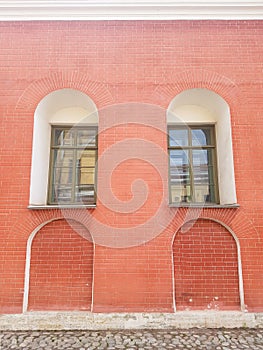 An old red brick wall and two green windows