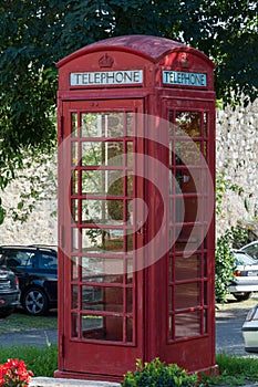 An old red british telephone booth from the front