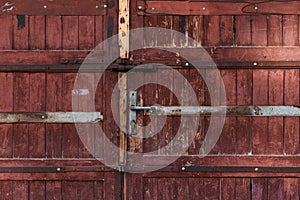 Old red brown wooden door with metal handle garage antique balkan aged with rusted metal bars in Sofia, Bulgaria