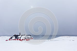 Old red building among snow at the fjord, Nuuk Greenland