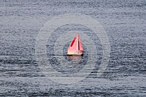 Old red buoy in a water during daytime