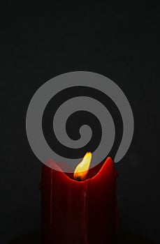 Old red candle with glimmer light flame on nice grey background, with blank upper space photo