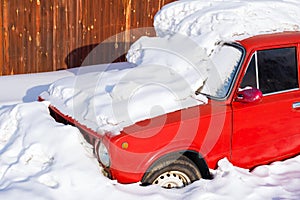 Old red car in the snowdrift