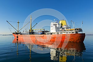 Old, red cargo boat at the sea