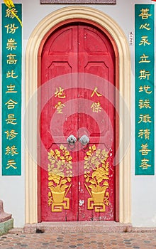 Old red chinese temple door with crave leaf photo