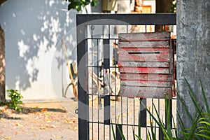 Old red color wood mail box on metal fence