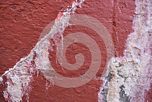 Old red concrete wall with cracked plaster. Abstract grunge background