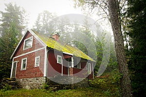 Old red cottage in the forest.