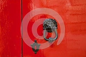 Old red door with lion head metal knockers