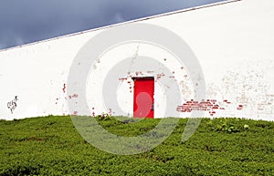 Old red door in white wall