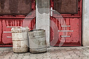 Old red doors with garbage baskets