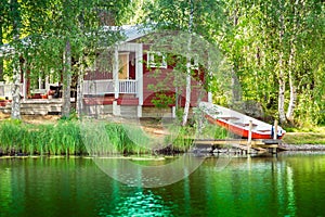Old red Finnish summer cottage at a lake photo