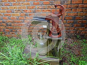 Old red hand operated water pump