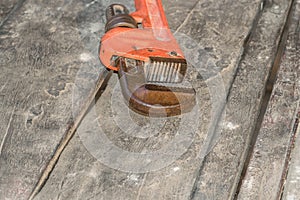 Old red heavy Pipe wrench on the ground