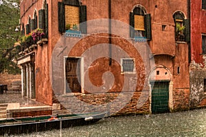 Old red house in Venice during rain, Italy.