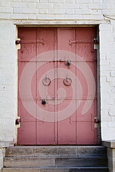 Old red metal door with white brick wall in Kolomenskoye park, M