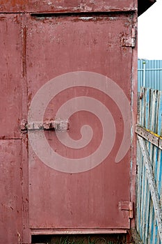 Old red metal garage door with a sation
