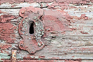 Old red paint rusty antique door keyhole or lock