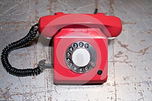 Old red phone on table - vintage telephone on desk