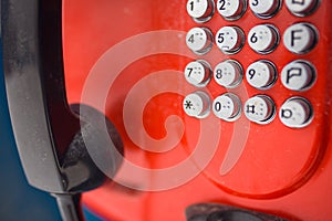 An old red push-button street phone-payphone.