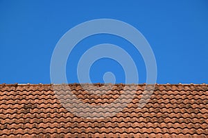 Old red roof tiles texture and blue sky background