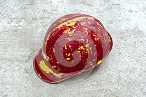 Old Red safety helmet with clipping path isolated on a concrete floor