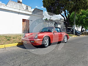 Old red sport car 1990s Porsche 911 Carrera 2 Type 964 cabriolet turbo look speedster in the street