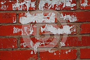 Old red stone brick with peeling white paper wall texture for background, pattern.