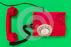 Old red telephone rings with handset off