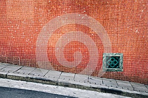 Old red tile wall and sloping street in Hong Kong