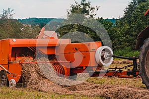 Old red tractor in the field, Ukrainian fields and old machinery, hay harvesting in the field