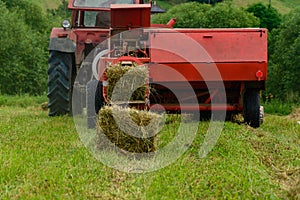 Old red tractor in the field, Ukrainian fields and old machinery, hay harvesting in the field