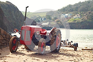 Old red tractor on Hope Cove beach, Devon, England