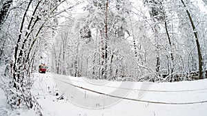 Old red tram on route 12 through a snowy forest.