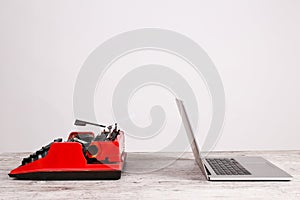 Old typewriter maschine and laptop on table. Concept of technology progress