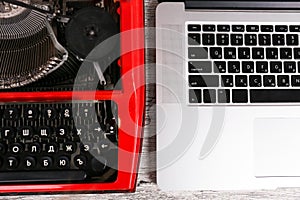 Old typewriter maschine and laptop on table. Concept of technology progress