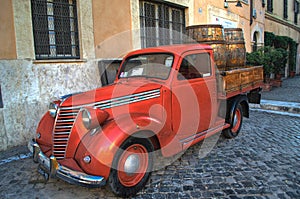 Old red vintage car in the center of Rome, Italy