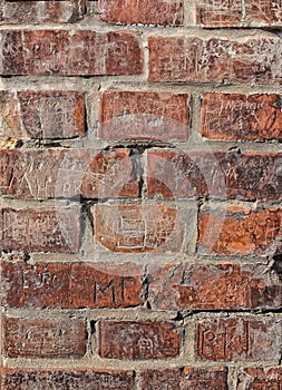 Old red wall with engraved bricks