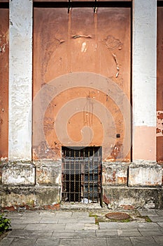 Old red wall with two columns and window