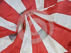 Old red and white stripe;  tent laying on the ground