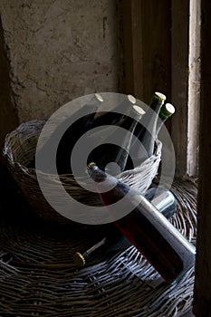Old red wine bottles in a wicker basket