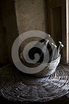 Old red wine bottles in a wicker basket