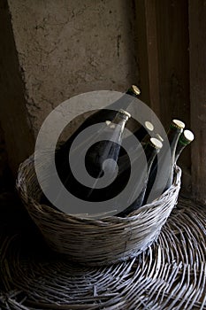 Old red wine bottles in a wicker basket