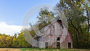 Old red wood barn in a autumn landscape